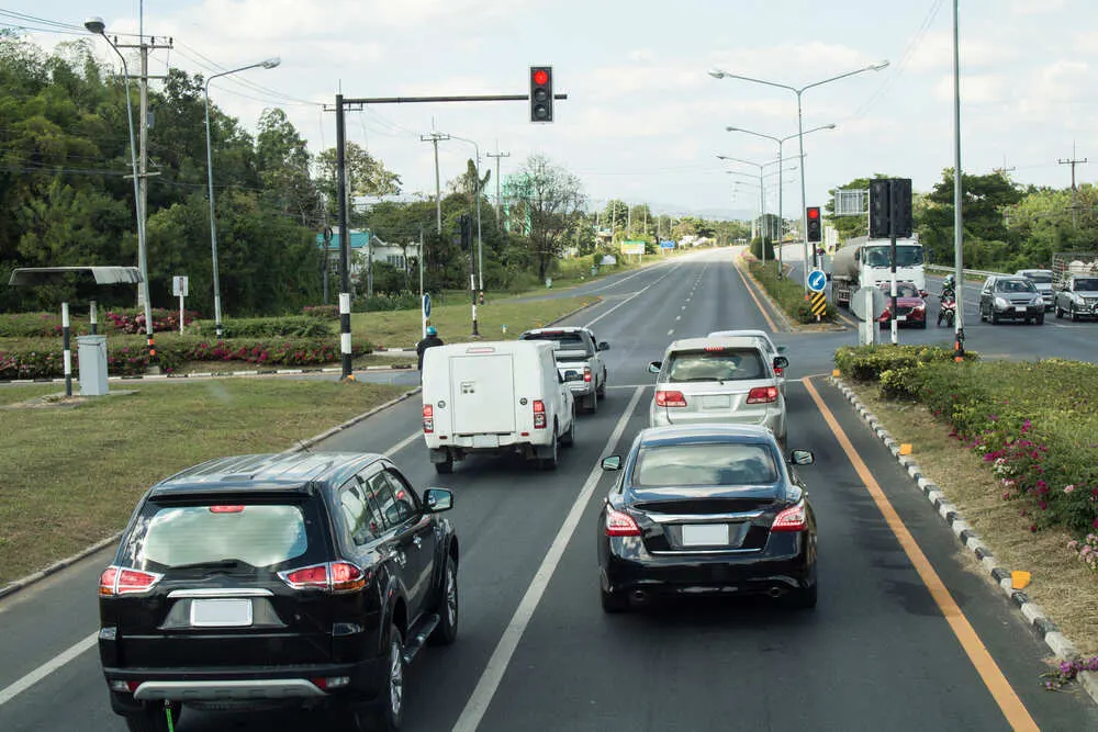 Cars stop red traffic light at the intersection of the Asian Highway
